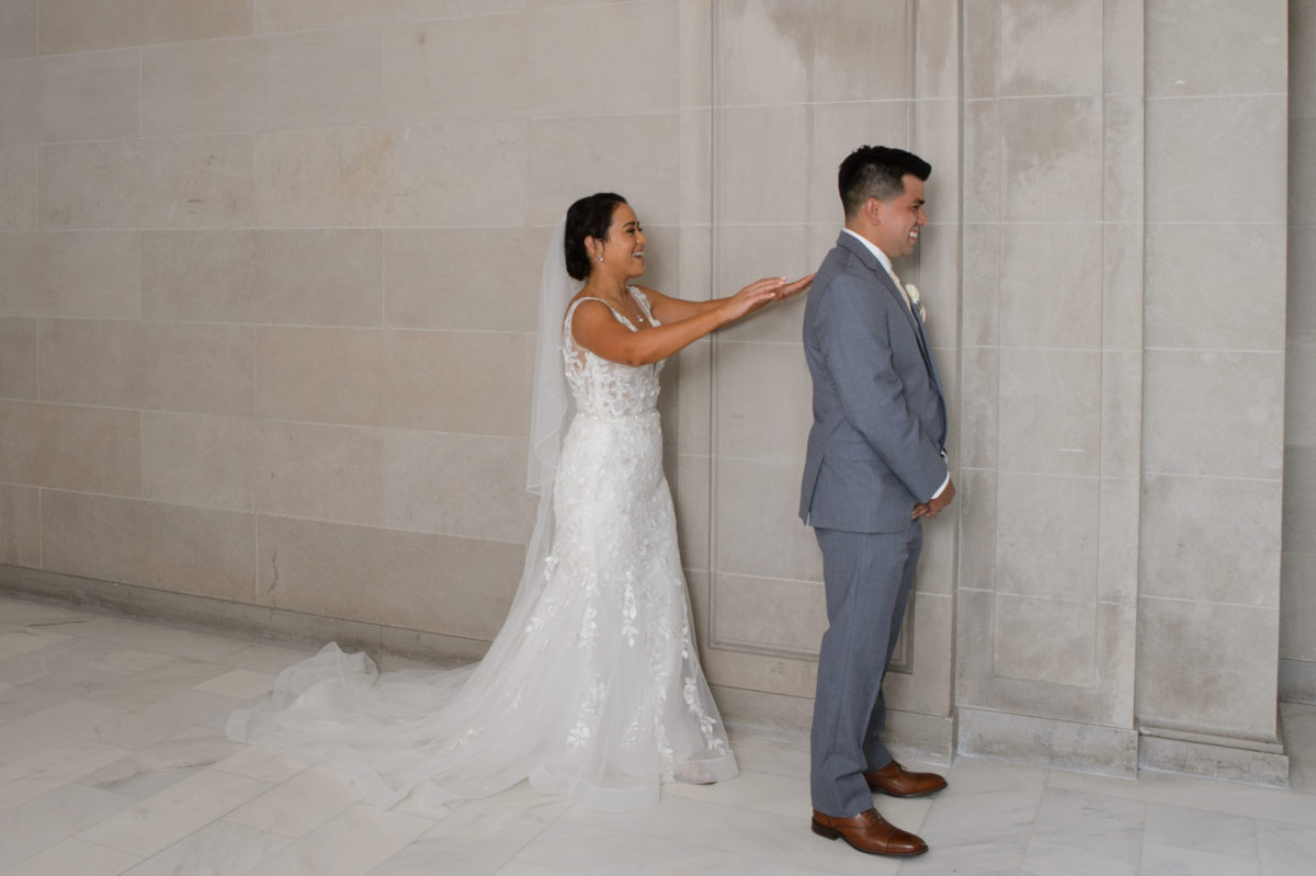 Bride tapping Groom on shoulder for First Look wedding ritual